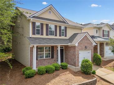 Charming two-story home featuring a brick facade, attached garage, and well-maintained landscaping at 181 Ridgemont Rd, Canton, GA 30114
