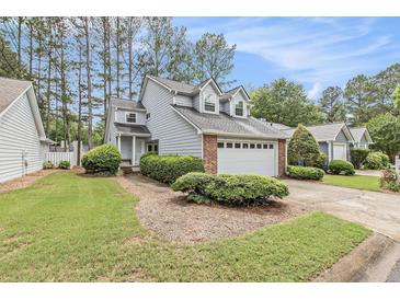 Charming two-story home with a well-manicured lawn, lush landscaping, and an attached two car garage at 114 Emily Ln, Alpharetta, GA 30009