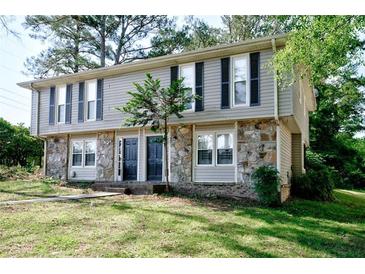 Traditional two-story home with stone accents, black shutters, and a well-maintained lawn at 1142 Forest Villa Nw Dr, Conyers, GA 30012
