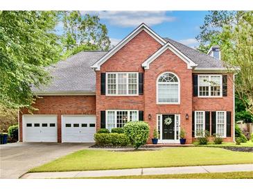 Beautiful two-story brick home with manicured lawn, black shutters, and a two car garage at 3990 Madison Main Nw, Kennesaw, GA 30144