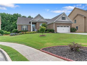 Charming brick home boasts a lush lawn, manicured landscaping and inviting curb appeal at 648 York View Dr, Auburn, GA 30011