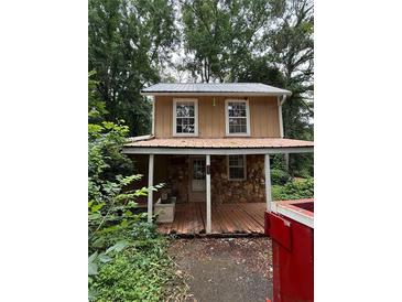 Rustic two-story home with a covered porch and metal roof nestled in a wooded lot at 352 Price Rd, Carrollton, GA 30116