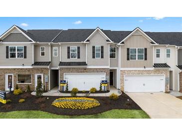 Charming townhomes feature brick accents, attached garages, and landscaped front yards in a desirable community at 1307 Aura Ln, Lawrenceville, GA 30045