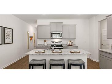 Bright kitchen with granite counters, stainless appliances, and a center island with seating at 3076 Yellowhammer Dr, Marietta, GA 30064