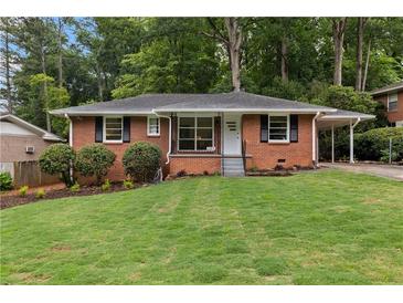 Charming brick home featuring a well-manicured lawn and a convenient carport at 1192 Willivee Dr, Decatur, GA 30033