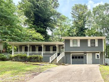 Charming home with a covered front porch, gray siding, and a well-maintained front yard at 654 Continental Dr, Lawrenceville, GA 30044