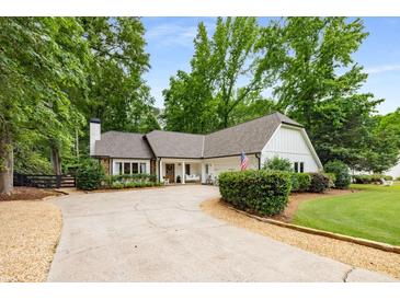 Charming single-story home with well-maintained landscaping and a long driveway at 7114 Surrey Pt, Alpharetta, GA 30009