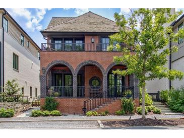 Charming brick home with a second-story balcony, arched entryway, and beautifully landscaped front yard at 210 4Th St, Fayetteville, GA 30214