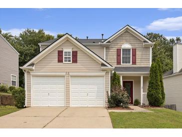 Two-story home with a two car garage, neutral siding, and landscaped front yard at 325 Meadows Ln, Canton, GA 30114