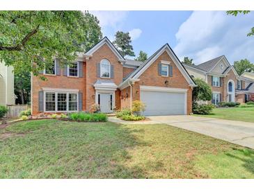 Charming two-story brick home with an attached two-car garage and manicured front lawn at 785 Cirrus Dr, Johns Creek, GA 30022