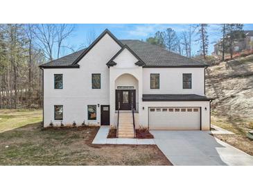 Beautiful two-story home with white brick, black trim, covered entry, and attached two-car garage at 4410 Ross Estates Ct, Snellville, GA 30039