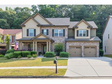 Charming two-story home with brick accents, attached garage, and well-manicured front lawn at 2525 Well Springs Dr, Buford, GA 30519