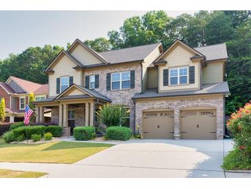 Charming two-story brick home with a well-manicured lawn, two car garage, and inviting front porch at 2525 Well Springs Dr, Buford, GA 30519
