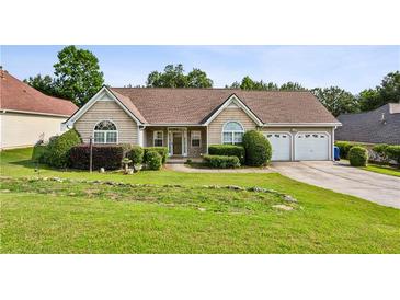 Charming single-story home with well-manicured lawn, mature landscaping, and a two-car garage at 99 Rainwater Ln, Dallas, GA 30157