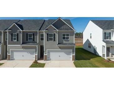 Charming townhome featuring an attached garage and neutral siding in a well-maintained community at 1309 Aura Ln, Lawrenceville, GA 30045