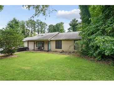 Charming single-story home with lush green lawn, mature trees and landscaping creating great curb appeal at 962 Brighton Dr, Lawrenceville, GA 30043