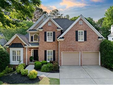 Charming two-story brick home featuring a well-manicured lawn, a two-car garage, and a welcoming front entrance at 112 Birchwood Pass, Canton, GA 30114