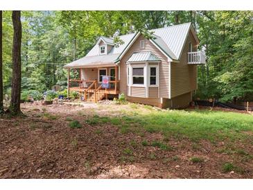 Charming home with a metal roof, inviting porch, and bay window, nestled among lush trees at 141 Mills Creek Path, Hiram, GA 30141