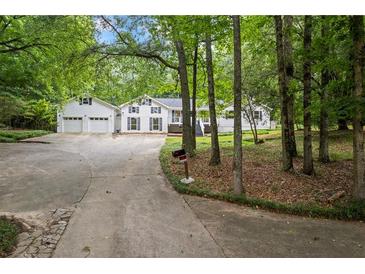 Charming two-story home with attached two-car garage and inviting curb appeal on a wooded lot at 3345 Bomar Rd, Douglasville, GA 30135