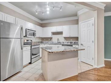 Bright kitchen features white cabinets, granite countertops, stainless steel appliances, and a center island at 1850 Cotillion Dr # 3305, Dunwoody, GA 30338