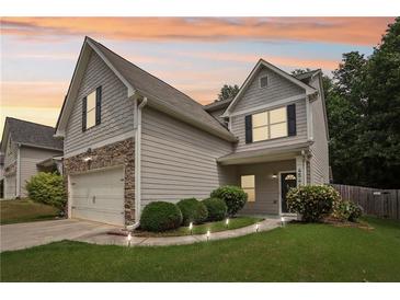 Charming two-story home with stone accents, a two-car garage, landscaped front yard, and cozy curb appeal at 4546 Water Mill Dr, Buford, GA 30519