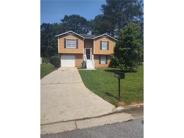 Charming home featuring a well-manicured front yard, a driveway, and a lovely two-story facade at 5653 Bradley Cir, Lithonia, GA 30038