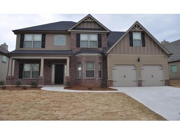 Charming two-story home with a brick and tan exterior, black shutters, and a covered front porch at 1530 Horseshoe Creek Ln, Cumming, GA 30041