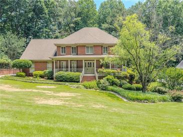 Beautiful two-story brick home with a well-manicured lawn and mature landscaping at 3290 Spain Rd, Snellville, GA 30039
