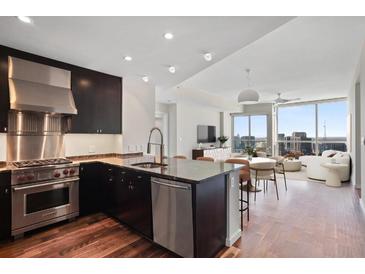 Modern kitchen with stainless steel appliances, dark cabinetry, and an open layout overlooking the living area at 3325 Piedmont Ne Rd # 2104, Atlanta, GA 30305