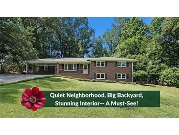 Charming brick home with a lush green lawn and mature trees provides a welcoming curb appeal at 1850 Donald Dr, Marietta, GA 30062