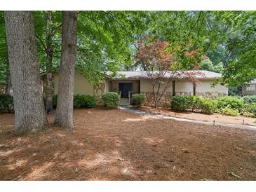 Charming single-story home featuring stone accents and mature trees in a serene setting at 217 Millbrook Farm Rd, Marietta, GA 30068