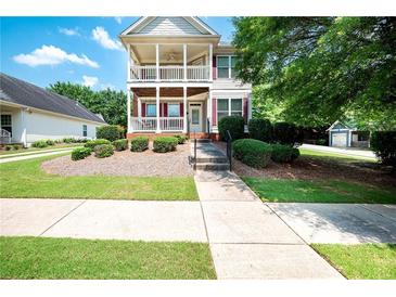 Charming two-story home featuring double balconies and a well-manicured front yard at 65 Orchard Dr, Covington, GA 30014