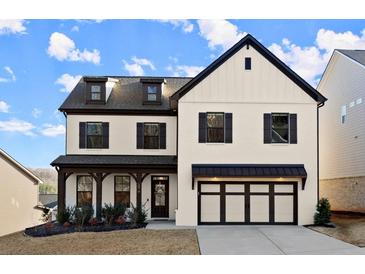 Beautiful two-story home with a modern farmhouse aesthetic, featuring a two car garage, covered entryway, and landscaped yard at 1590 Branthaven Ln, Auburn, GA 30011