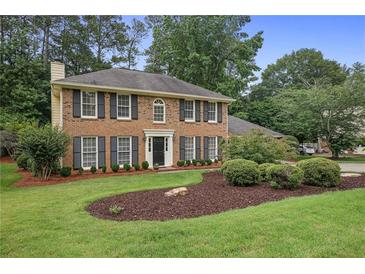 Charming two-story brick home with a manicured lawn and lush landscaping at 1338 Nonie Way, Marietta, GA 30062