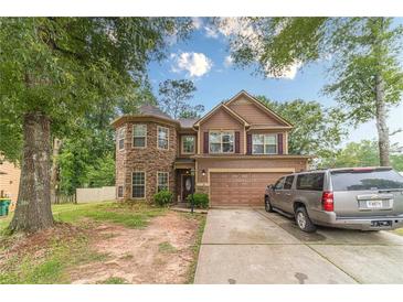 Charming two-story home featuring stone accents and a two-car garage, nestled on a lush lot at 568 Musical Ct, Lawrenceville, GA 30044