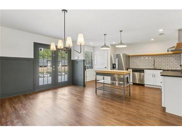 Spacious kitchen and dining area with stainless steel appliances and modern lighting at 355 Winding River Dr # B, Atlanta, GA 30350