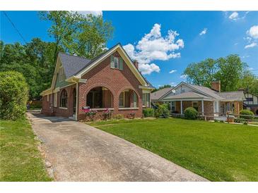 Charming brick home featuring a well-maintained front yard, arched porch and inviting curb appeal at 1391 Jefferson Ave, East Point, GA 30344