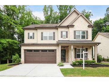 Charming two-story home featuring a brick facade, covered porch, and a two-car garage at 2630 Timler Trce, Snellville, GA 30078
