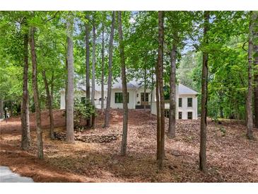 Charming home nestled among mature trees on a well-manicured, sloped lot at 12995 Bucksport Dr, Roswell, GA 30075