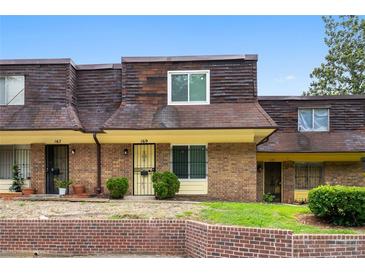 Charming townhouse with brick facade, yellow trim, and well-kept front lawn at 169 Peyton Sw Pl, Atlanta, GA 30311