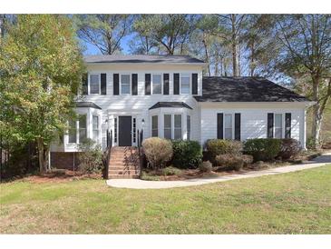 Charming two-story home with a landscaped front yard, black shutters, and a welcoming entrance at 1192 Melton Sw Dr, Lilburn, GA 30047