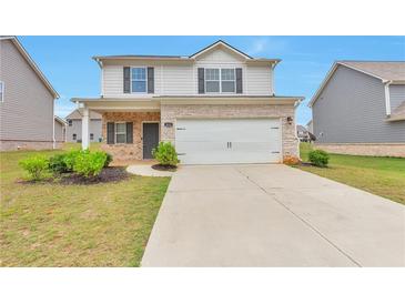 Charming two-story home with stone accents, a two-car garage, and a well-maintained front yard at 513 Moline Way, Locust Grove, GA 30248