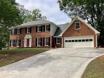 Traditional two-story brick home with black shutters, a red front door, and attached two car garage at 3243 Northbrook Dr, Atlanta, GA 30341