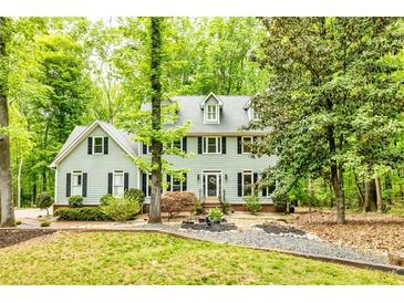 Traditional two-story home with black shutters, mature trees, manicured lawn, and meticulous landscaping at 120 Majesty Ln, Fayetteville, GA 30215