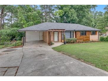 Charming single-story home with brick and wood siding, a covered carport, and a inviting pergola entryway at 2468 Dresden Ne Dr, Atlanta, GA 30341