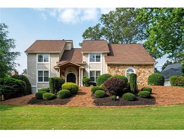 Charming home featuring a blend of stucco and stone facade, complemented by a well-manicured lawn and landscape at 2917 Ashebrooke Ne Dr, Marietta, GA 30068
