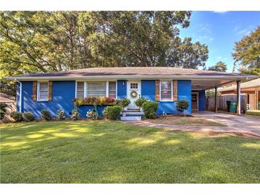 Charming blue brick home with well-maintained lawn, flower boxes, and carport at 854 Parkway Se Dr, Smyrna, GA 30080