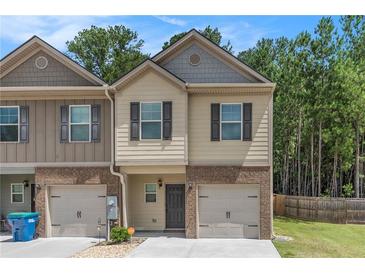 Charming two-story townhome with single-car garage and manicured lawn at 3473 Shoal Oak Ct, Riverdale, GA 30296