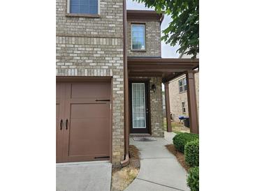 Brick home featuring a garage and covered front entry at 6585 Story Cir, Norcross, GA 30093