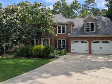 Charming brick home featuring a well-manicured lawn and a two-car garage at 5882 Grandview Nw Ct, Acworth, GA 30101